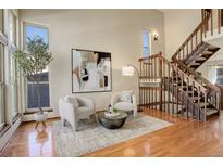 Bright living room with hardwood floors, a staircase, and comfortable seating at 722 S Eagle St, Aurora, CO 80012