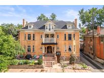 Stately brick home featuring a welcoming front porch and manicured landscaping at 2124 E 17Th Ave # 4, Denver, CO 80206