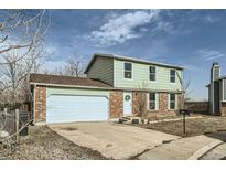 Two-story house with green siding, attached garage, and landscaping at 11058 Grange Creek Dr, Thornton, CO 80233