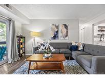 Inviting living room features a plush gray sofa, wood coffee table, and bright natural light at 14435 E 1St Dr # B2, Aurora, CO 80011