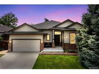 Charming single-Gathering home showcasing a well-maintained lawn, two-car garage, and inviting front entrance at 10553 Stonemeadow Dr, Parker, CO 80134