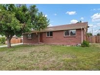 Charming brick home with a well-manicured lawn, mature trees, and a cozy front porch perfect for relaxing at 6698 S Wellington Ct, Centennial, CO 80121