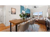 Open-concept living and dining area with modern decor, balcony, and city views at 1950 N Logan St # 905, Denver, CO 80203