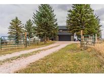 Charming two-story home featuring a spacious driveway, mature trees, and a two-car garage at 2312 Arabian Trl, Elizabeth, CO 80107