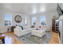 Bright living room features modern decor, hardwood floors, large windows and plush, comfortable seating arrangement at 4625 W 50Th Ave # 203, Denver, CO 80212