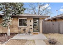 Charming single-story home features a brick facade, modern front door, and cozy outdoor seating area at 2810 N Harrison St, Denver, CO 80205
