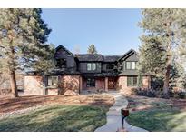 Stunning two-story brick and dark siding home with mature trees and manicured lawn at 1 Winged Foot Way, Littleton, CO 80123