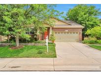 Charming single-Gathering home with brick facade, green lawn, mature trees, and a two-car garage at 6731 E 128Th Pl, Thornton, CO 80602