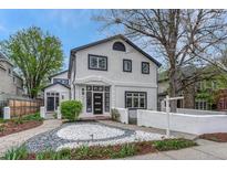 Stunning two-story home showcasing modern design with white stucco and contrasting dark trim, a landscaped yard, and a welcoming walkway at 520 Columbine St, Denver, CO 80206