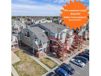 Inviting condo complex featuring ample parking, exterior stairways, and a well-maintained green space at 970 S Dawson Way # 15, Aurora, CO 80012