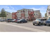 Three-story condo building featuring brick accents, exterior staircases, and ample parking in the complex at 970 S Dawson Way # 15, Aurora, CO 80012