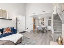 Inviting living room with hardwood floors, staircase, and abundant natural light creating a warm and welcoming atmosphere at 970 S Dawson Way # 15, Aurora, CO 80012