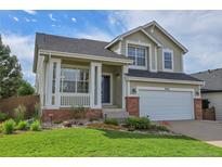 Charming two-story home with well-manicured lawn, covered porch, and attached two-car garage at 10115 Foxridge Ct, Highlands Ranch, CO 80126
