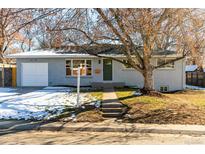 Charming single-story home with a well-maintained front yard, and attached garage, painted in a neutral gray tone at 4110 W Floyd Ave, Denver, CO 80236