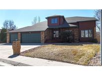 Charming two-story home with brick and wood accents, green trim and a spacious three-car garage at 1982 E 129Th Dr, Thornton, CO 80241