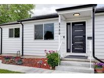 Charming white home featuring a modern black front door and well-maintained landscaping at 2389 Nome St, Aurora, CO 80010