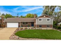 Charming home featuring a well-manicured lawn, brick accents, and an attached garage at 10009 Dodge Dr, Northglenn, CO 80260