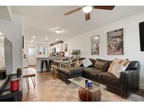 Inviting living room with a large sectional couch, open to the kitchen, creating a seamless living space at 4820 W 13 Ave, Denver, CO 80204