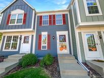 Charming townhome featuring colorful siding, red shutters, and a well-maintained front yard at 960 Milo Cir # B, Lafayette, CO 80026