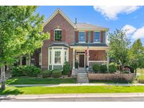 Charming two-story brick home with landscaped front yard and welcoming front porch at 8318 Devinney Ct, Arvada, CO 80005