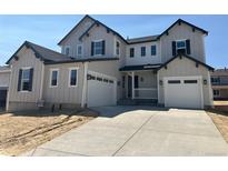 Charming two-story home with light-grey siding, black trim, an attached two-car garage, and an inviting front porch at 5500 Tamarack Ave, Firestone, CO 80504