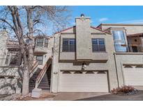 Charming townhome featuring a two-car garage and stucco siding, complete with a cozy front porch entrance at 1530 S Quebec Way # 34, Denver, CO 80231