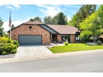 Charming brick home featuring a manicured lawn, mature trees, and a two-car garage at 3253 S King Way, Denver, CO 80236