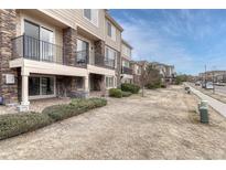 Attractive multi-story townhome with stone accents and well-maintained landscaping at 14902 E Poundstone Dr, Aurora, CO 80015