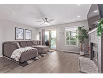 Inviting living room featuring a comfortable sectional sofa, fireplace, and sliding glass doors to a deck at 12183 W Chenango Dr, Morrison, CO 80465
