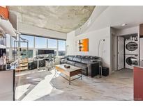Modern living room with city views, leather sofa, and marble floors at 891 14Th St # 2816, Denver, CO 80202
