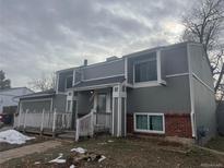 Charming two-story home featuring a cozy front porch, gray siding, and brick accents, creating a welcoming curb appeal at 15716 E Temple Pl, Aurora, CO 80015