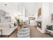 Bright living room featuring modern furnishings, a fireplace, and a spacious open floor plan to the kitchen and dining area at 5444 Zephyr St # 203, Arvada, CO 80002