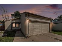 Charming home exterior showcases a two-car garage, well-maintained lawn, and cozy curb appeal at 7834 S Windermere Cir, Littleton, CO 80120