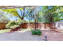 Private backyard patio featuring brick walls, mature trees, and a well-maintained landscape at 2500 S York St # 116, Denver, CO 80210
