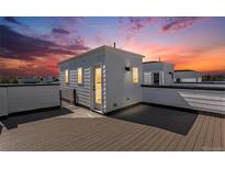 A rooftop deck with composite planks and a small building offers a private outdoor space with sunset views at 888 S Valentia St # 101, Denver, CO 80247