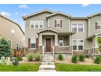 Charming two-story townhouse featuring a covered porch, stone accents, and landscaped front yard at 4343 S Nepal Ct, Centennial, CO 80015
