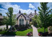 Charming home with beautiful landscaping, a tiled roof, and a stone facade at 9042 E Vassar Ave, Denver, CO 80231
