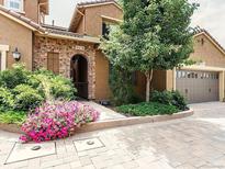 Charming front exterior features a beautiful stone archway, landscaped yard, and attached two-car garage at 9218 Viaggio Way, Highlands Ranch, CO 80126