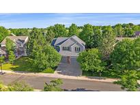 Charming two-story home featuring a manicured lawn, mature trees, and a welcoming gray exterior at 5746 Aspen Creek Dr, Broomfield, CO 80020