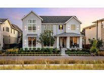 Stunning two-story home with gray siding, manicured landscaping and inviting front porch at 6123 Chester Way, Denver, CO 80238