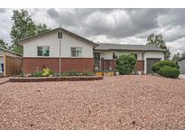 Charming ranch-style home with a brick accent and a well-maintained yard filled with decorative pink crushed gravel at 6346 Fenton St, Arvada, CO 80003
