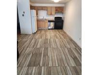 Well-lit kitchen with stainless steel dishwasher, white appliances, and wood cabinets at 1304 S Parker Rd # 359, Denver, CO 80231