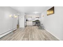 Bright living room and kitchen area with stainless steel appliances and modern light fixtures at 1304 S Parker Rd # 359, Denver, CO 80231