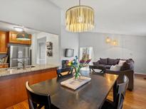 Open-concept dining room featuring a modern light fixture and seamless flow into the cozy living area at 11256 W 104Th Ave, Broomfield, CO 80021