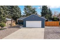 Charming blue home with a two-car garage and well-maintained front yard at 3064 S Holly Pl, Denver, CO 80222
