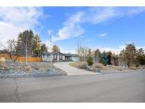 Charming single-story home with a circular driveway and mature trees on a sunny day at 9783 Zephyr Dr, Broomfield, CO 80021