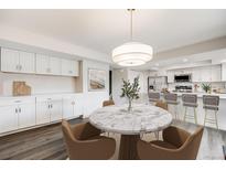 Bright dining area with a marble table, stylish light fixture, and seamless flow into the modern kitchen at 3964 S Yosemite St, Denver, CO 80237