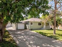 Charming home with a well-maintained lawn and long driveway leading to a detached garage at 4125 Pierce St, Wheat Ridge, CO 80033