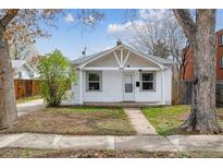 Charming white bungalow with classic architectural details and a cozy front yard at 4046 S Bannock St, Englewood, CO 80110