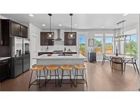Bright eat-in kitchen featuring a spacious island with barstool seating and modern stainless steel appliances at 6700 Clay St, Denver, CO 80221